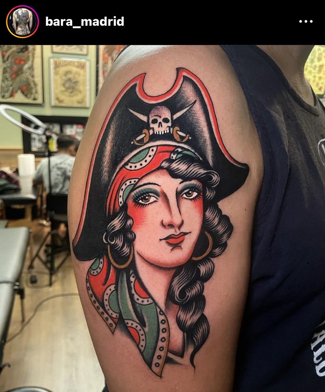 American traditional tattoo of a pirate woman with a tricorn hat on a person's shoulder.