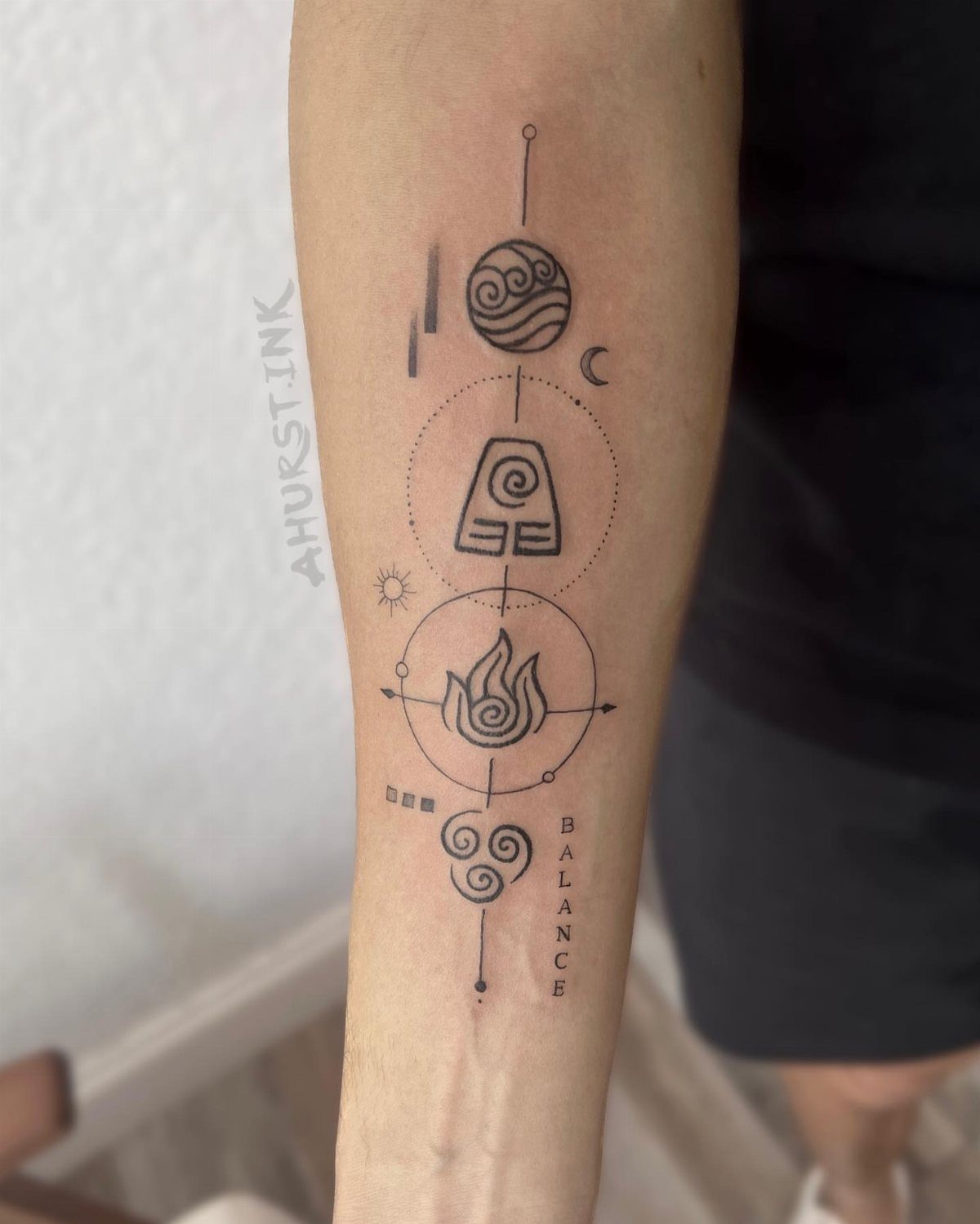 5 Avatar Elements Tattoo Ideas for a Clean, Story-Driven Design 1 Black ink elemental symbol tattoos arranged vertically on a person's forearm with small celestial accents.