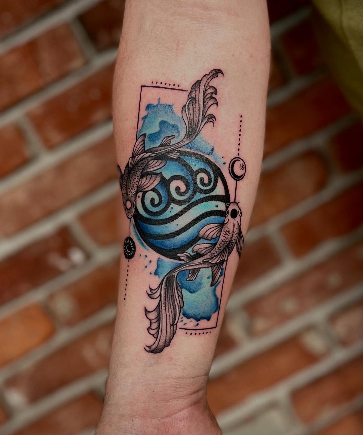 5 Avatar Elements Tattoo Ideas for a Clean, Story-Driven Design 2 Koi fish tattoo with blue watercolor splashes and circular wave elemental symbols on a forearm.