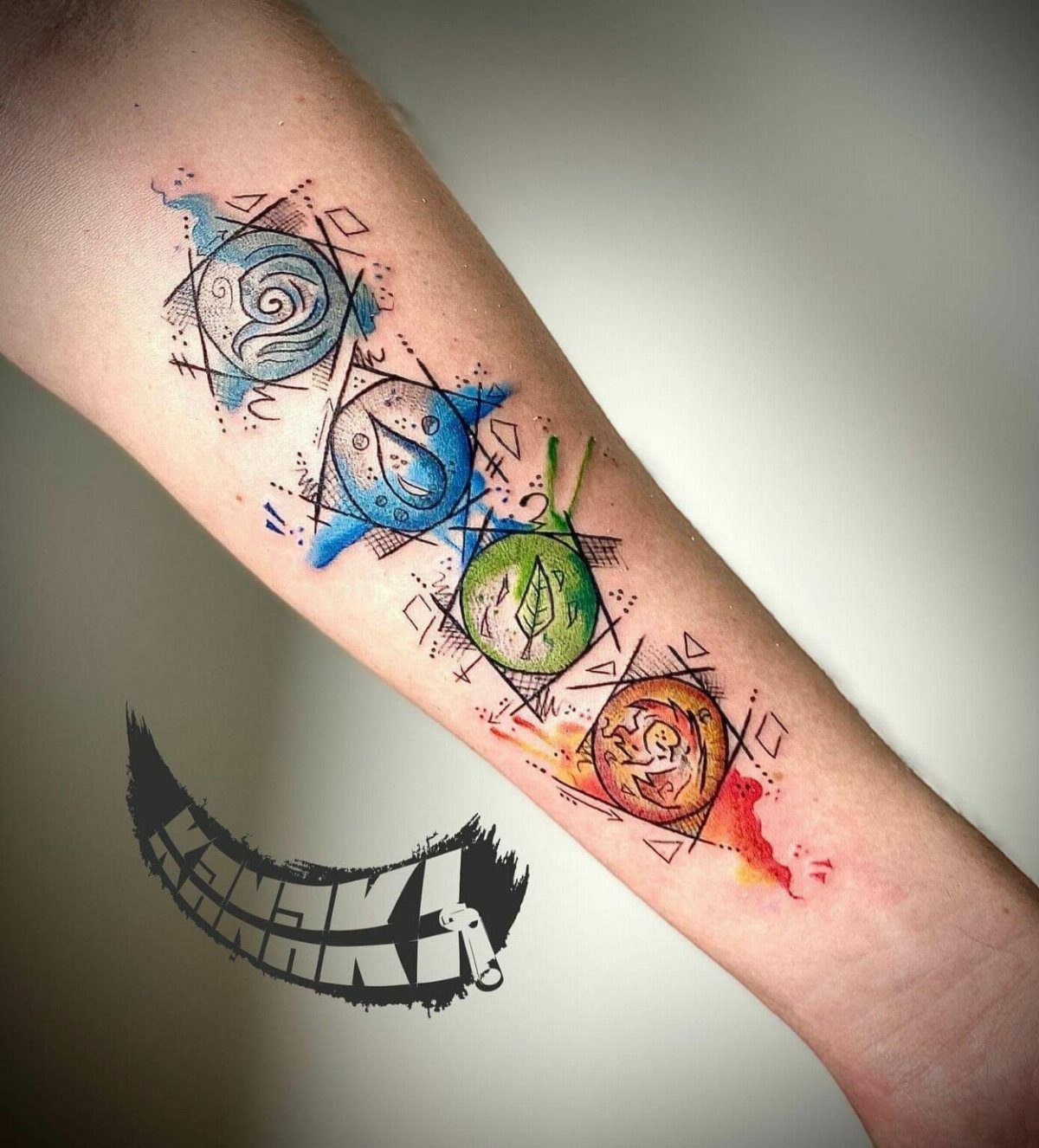 Four Elements Tattoo Design: 7 Styles That Hold Their Own 3 Four elemental symbol tattoos with colorful watercolor splashes on a person's forearm.