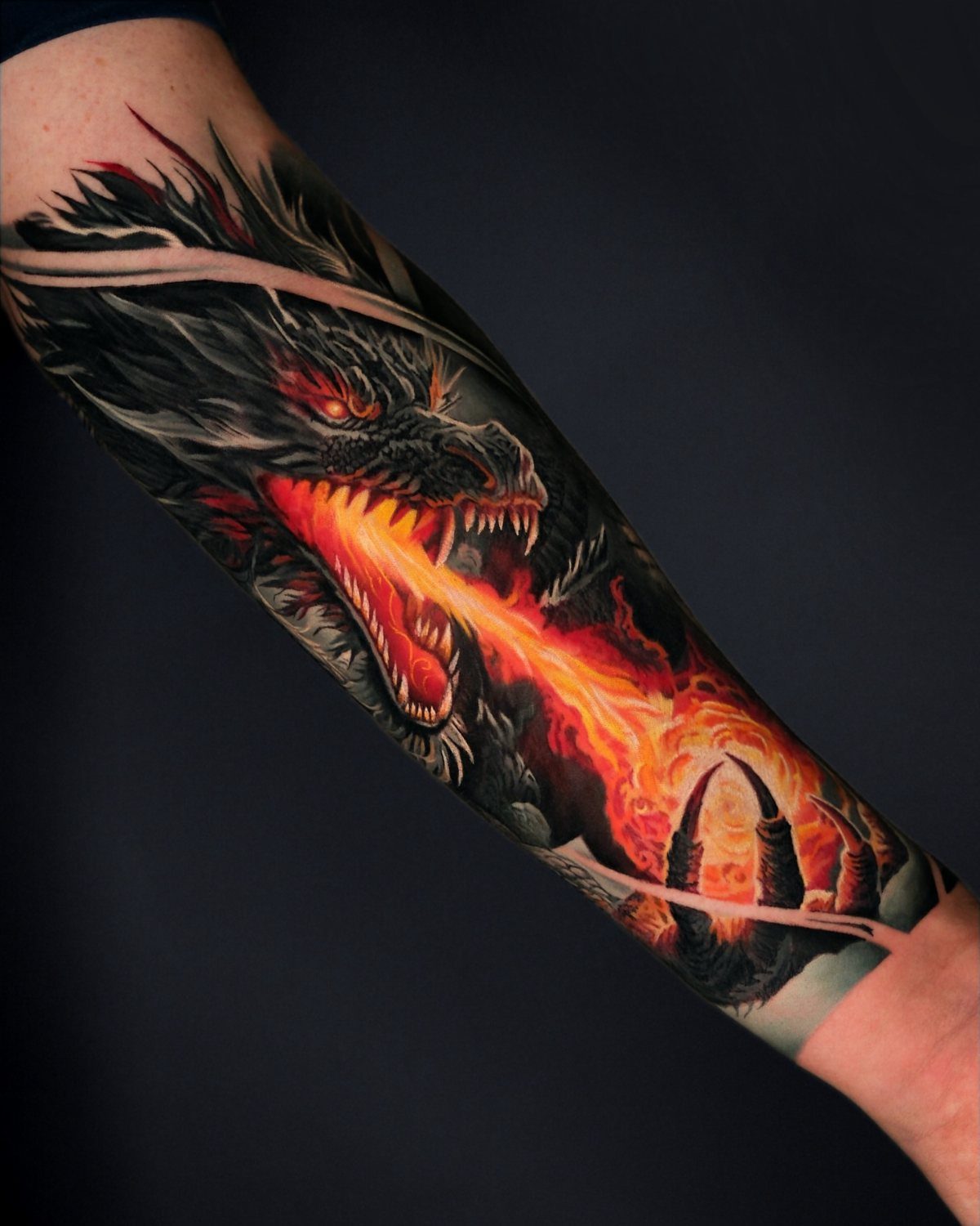 Japanese Dragon Tattoos: 19 Designs With Meaning and Style 10 A detailed black dragon tattoo on a forearm breathing bright orange flames.