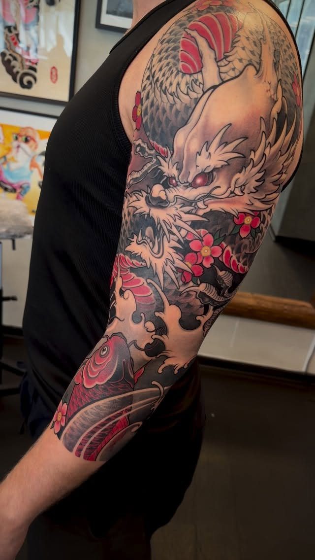 Japanese Dragon Tattoos: 19 Designs With Meaning and Style 2 A detailed Japanese sleeve tattoo featuring a dragon head and a red koi fish.