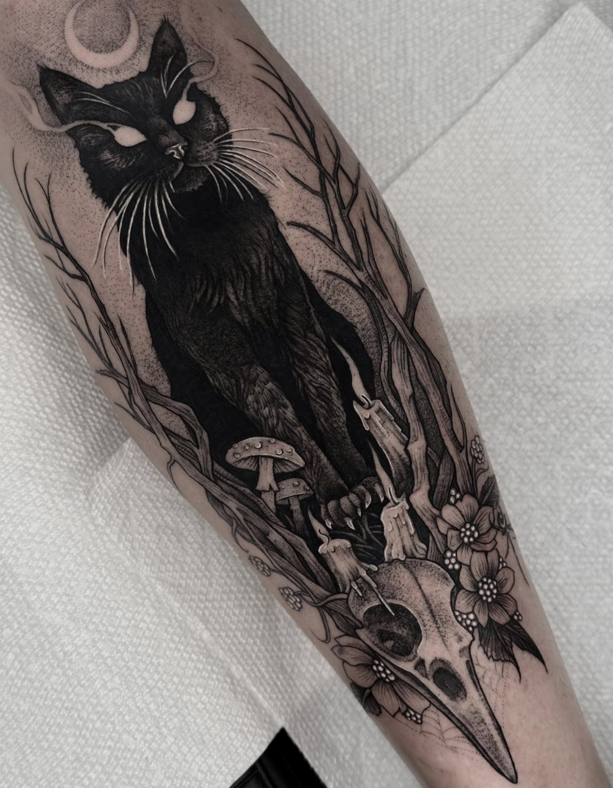 8 Tattoo Pattern Gothic Ideas: From Crows to Cathedral Arches 3 A detailed black ink gothic tattoo of a black cat with a skull and mushrooms.
