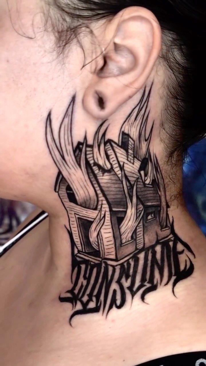 7 Tattoo Style Home Designs for Your Next Ink 6 A black and grey neck tattoo of a house engulfed in large, stylized flames.